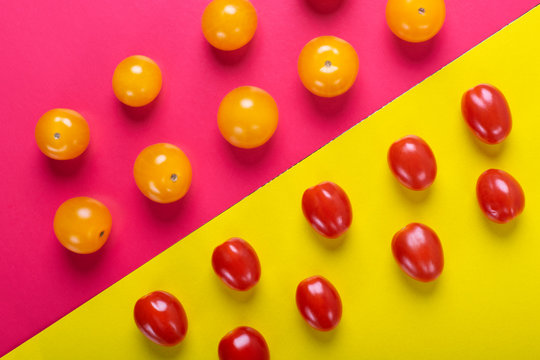 Red and yellow cherry tomatoes on the multicolored geometric background