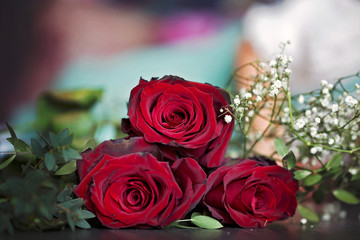 Beautiful toddler boy, holding red roses for mother's day