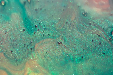 green and pink alcohol ink with glitter dissolved in water, abstract background, macro shot - 321862715