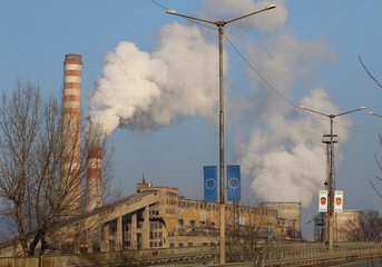 Old smoking chimney of thermal power station plant background of blue
