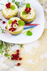 Gentle, festive cupcake with cream and berries аnd a candle a light background