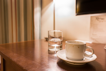 Hotel room water and coffee on a wooden table.