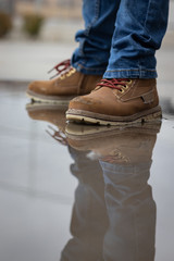 Water and fund with booths. Kid is jumping and splashing on a water mud in the street, wearinf...