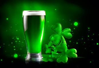St. Patrick's Day Green Beer pint over dark green background, decorated with shamrock leaves. Patrick Day Irish pub party, celebrating. Glass of Green beer close-up. Border art design, Wide format