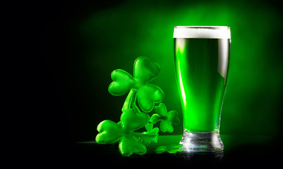 St. Patrick's Day Green Beer pint over dark green background, decorated with shamrock leaves. Patrick Day Irish pub party, celebrating. Glass of Green beer close-up. Border art design, Wide format