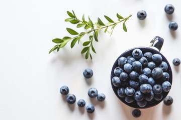 Blueberry explosion. Photo of blueberry in cup on white table. Top view. Healthy food, health