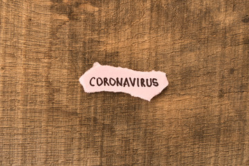 Coronavirus. 2019-nCoV. The inscription CORONAVIRUS on a piece of paper on a wooden background. The concept of virus protection. Selective focus.