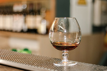 a glass of whiskey by bar