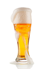 Glass of light beer with foam  on white background
