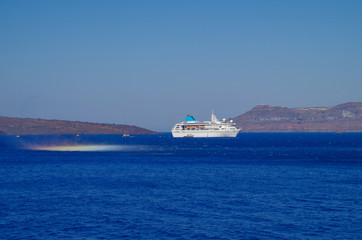 White classic Celestyal Cruises cruiseship or cruise ship liner anchored in bay of volcanic Greek...