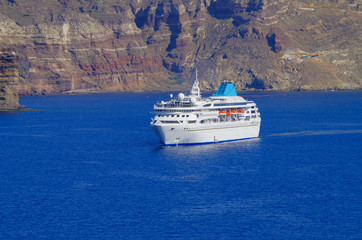 White classic Celestyal Cruises cruiseship or cruise ship liner anchored in bay of volcanic Greek...