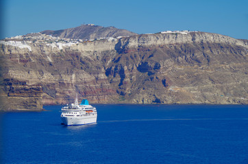 White classic Celestyal Cruises cruiseship or cruise ship liner anchored in bay of volcanic Greek...