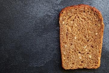 black rye bread with useful additives and seeds (bakery slices) menu concept background. top view. copy space