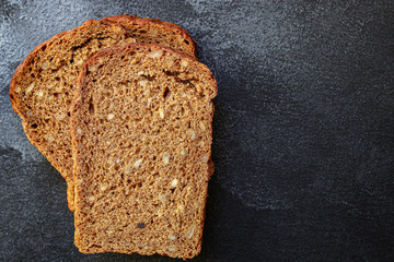 black rye bread with useful additives and seeds (bakery slices) menu concept background. top view. copy space