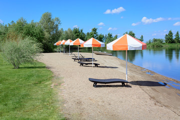 Beach lounger with umbrella for sun protection.