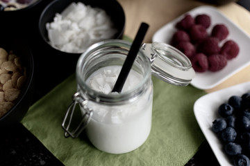 Fototapeta na wymiar gesundes Kokos Reis Getränk mit Kokosflocken im Einmachglas mit Strohhalm in entsättigten Farben