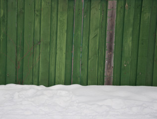 old green fence under the snow
