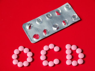 OCD concept with pink pills on red background and empty blister pack compulsive disorder