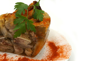 Traditional Romanian homemade pork trotter jelly dish called piftie. Jellied pork aspic made with pork meat served with paprika and fresh parsley.