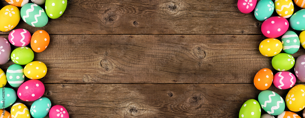Poster colorful easter egg banner with double side border against a rustic old wood background. above view 