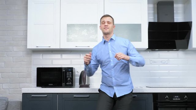 young handsome man dancing in the kitchen. lifestyle