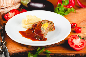 Zrazy cutlets with minced meat, rice and eggs served with mashed potatoes on white plate.