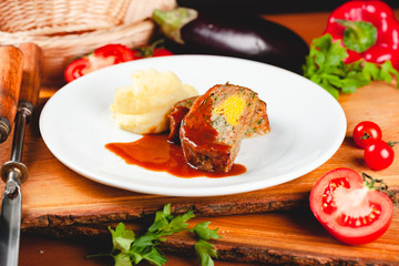 Zrazy cutlets with minced meat, rice and eggs served with mashed potatoes on white plate.
