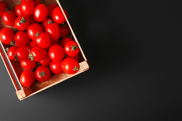 черри томаты в ящике на черном фоне