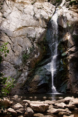A tranquil waterfall in California with rocks in the foreground