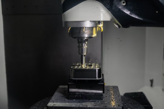 Industrielle CNC Fr&auml;smaschine bearbeitet einen Metallblock aus Stahl