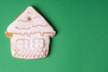 Handmade cookies in glaze in the form of Christmas toys on a green background.
