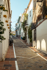 Fototapeta na wymiar Marbella, Spain - August 26th, 2018. Typical old town street with Spanish architecture in Marbella, Costa del Sol, Andalusia, Spain, Europe