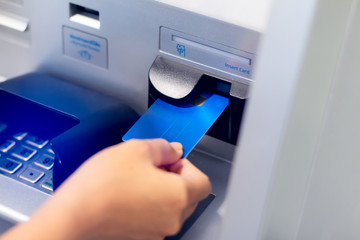 Man's hand inserting a credit card in ATM , Hand inserting ATM plastic card into bank machine to withdraw money, finance money bank concept, Selective focus at some part of the credit card
