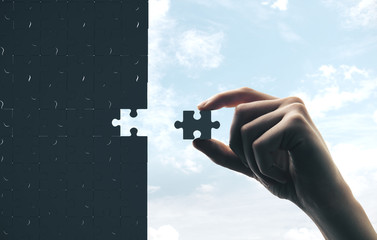 Hand putting gray puzzle
