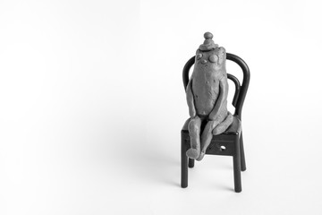 plasticine cat is sitting on a chair. Isolated object.