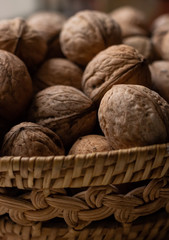 Small wicker basket filled with walnuts on a white background