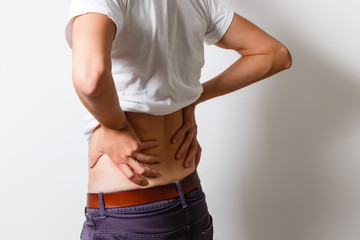A man holds on to his back, his back hurts, his red back, spinal hernia, intervertebral hernia