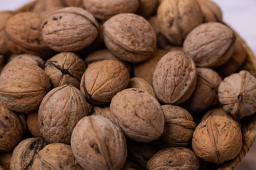 Walnuts close-up. A lot of nuts in a small basket. Background