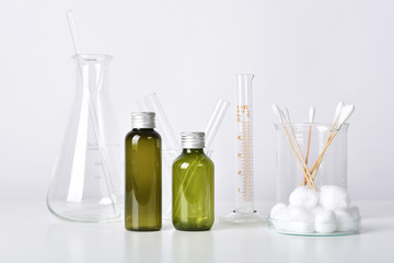 Cosmetic bottle containers and scientific glassware, Blank package for branding mock-up, Pharmaceutical skincare by dermatologist doctor, Research and develop beauty product concept.