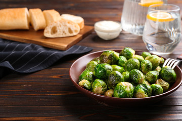 Roasted Brussels sprouts in plate on wooden table
