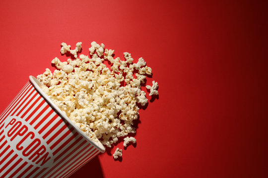 Delicious popcorn on red background, top view. Space for text