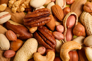 Different delicious nuts as background, closeup view