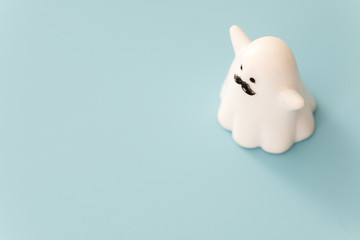 small white color plastic ghost figure in blue background view