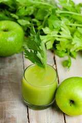 Healthy eating, food and vegetarian diet concept - glass of fresh green apple and celery juice or smoothie. Antioxidant detox beverage. Clean organic ingerdients. Close up, wooden background.