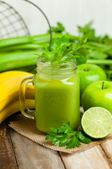 Healthy eating, food and vegetarian diet concept - mason jar of fresh juice or smoothie with apple, celery. Antioxidant detox beverage. Organic ingerdients. Close up, wooden background, copy space