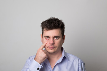 Attractive young man. Angry business man. Studio image of a tired man.