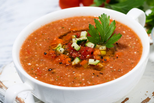 cold tomato soup in a bowl on white background, closeup