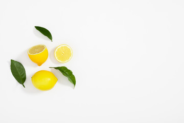 Creative pattern made of lemon and leaves. Lemon on white background. Food concept. Flat lay, top view, copy space