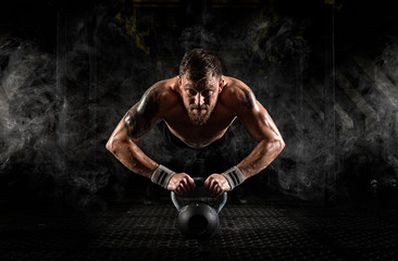 Man doing push ups on kettle ball