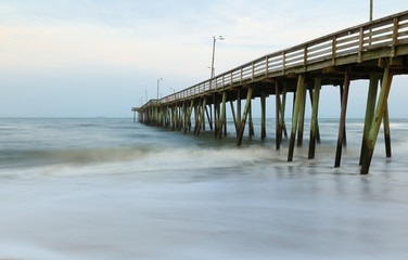 Fototapeta na wymiar Fishing Pier after sunset at Virginia Beach, Virginia, USA. Long Exposure Applied to slow the water motion.